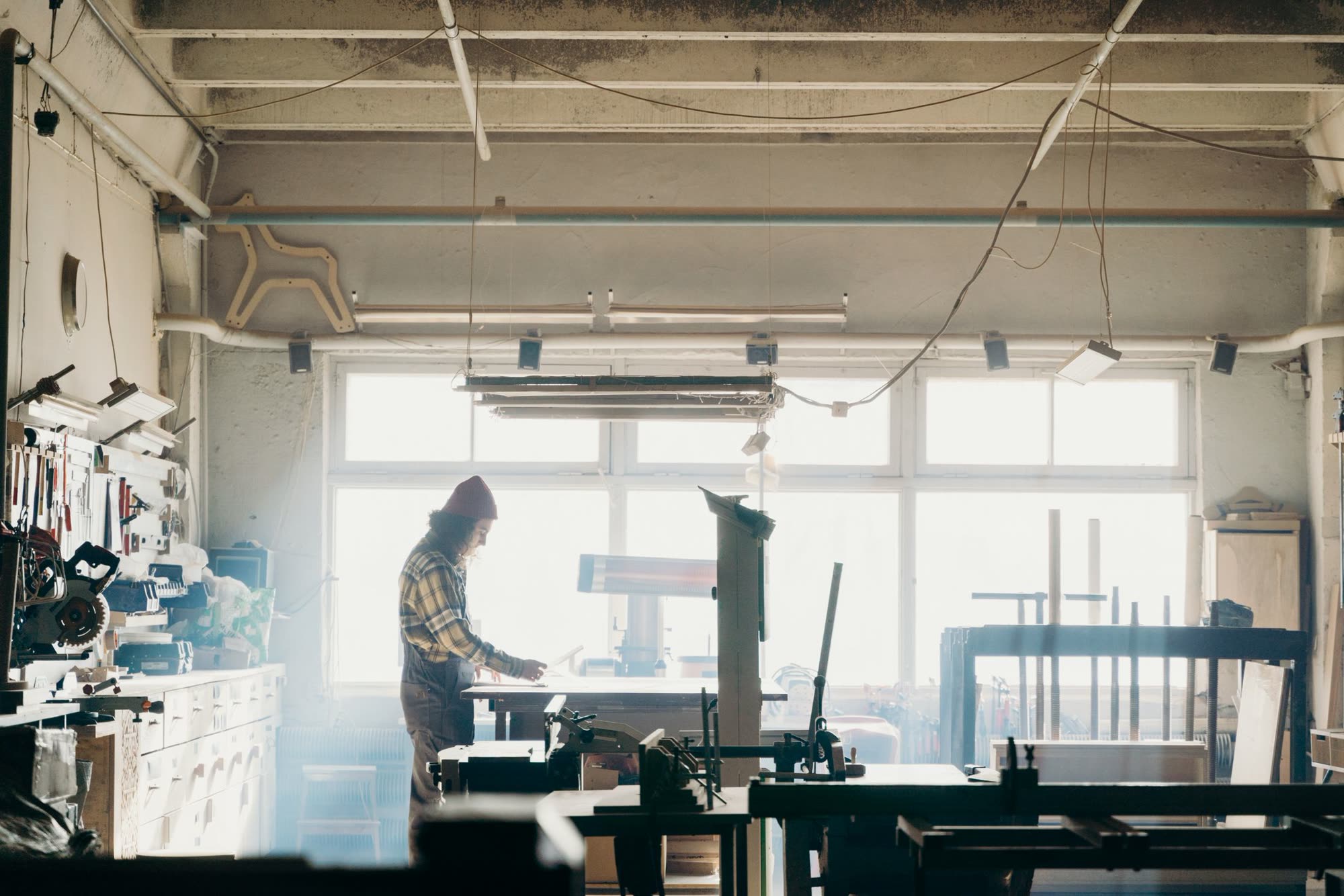 Woodworker at a bench in a bright cabinet shop